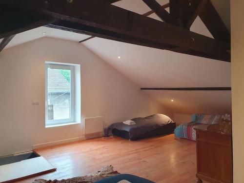 une chambre mansardée avec deux lits et une fenêtre dans l'établissement Le fourneau des pianistes, à Nilvange