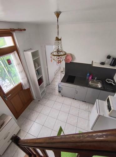 - une vue de tête sur une cuisine dotée d'un lustre dans l'établissement Jolie Appartement maison très bien placé, à Épinay-sur-Seine