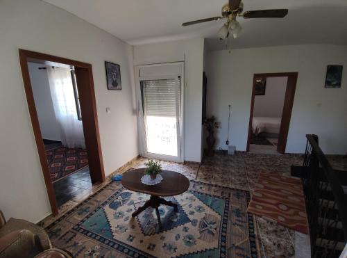 ein Wohnzimmer mit einem Tisch und einem Deckenventilator in der Unterkunft Cozy Room in the Old Town in Gjirokastër