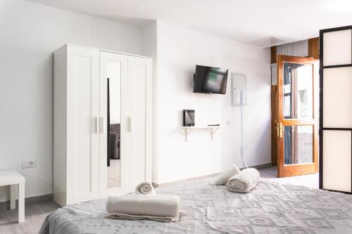 Un dormitorio con una cama y un televisor en una pared. en Le&La, en Santa Cruz de la Palma