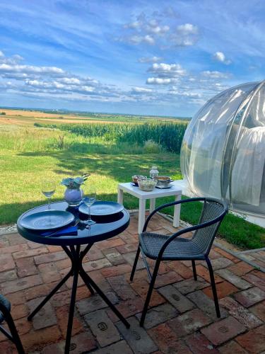 a patio with two chairs and a table and a glass dome at Buby - végtelenbe és tovább in Szigetvár