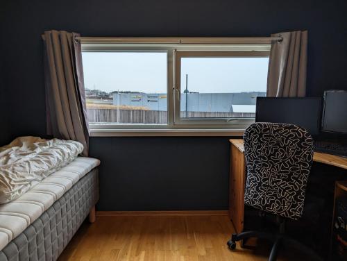 a bedroom with a desk and a chair and a window at Green appartement in Sandnes
