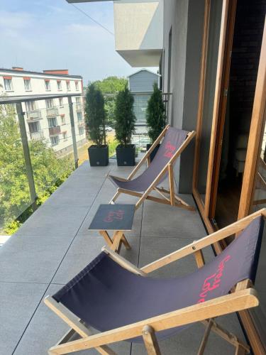 two lounge chairs sitting on a balcony at Apartament Grey Love w Czeladzi, FV, 8km do Katowic in Czeladź