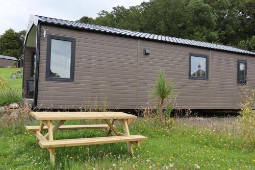 a picnic table in front of a tiny house at Cabin Cynthia in Llwyngwril