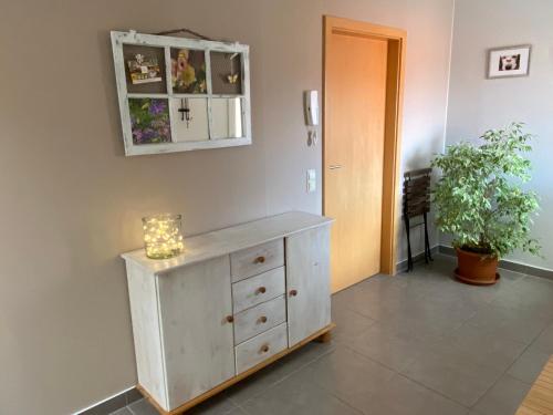 a room with a dresser with a mirror and a plant at Gemütliches Appartment in Tucheim in Tucheim