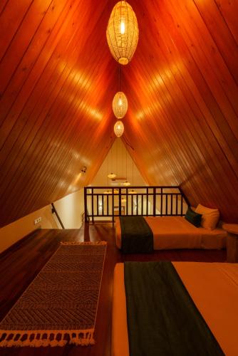 a bedroom with two beds in a room with a ceiling at Majentra Ella in Ella