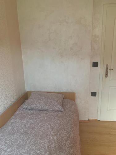a small bedroom with a bed and a white door at Kuca Milosevic in Lug