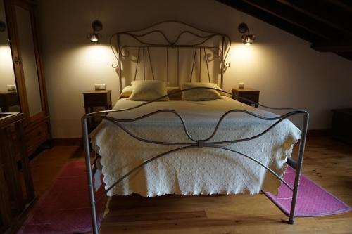 a bedroom with a bed with a metal frame at HOTEL RURAL ARREDONDO in Celorio