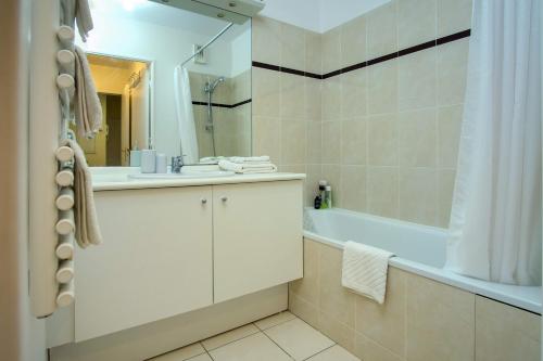 a bathroom with a sink and a tub and a shower at Cute garden apartment - Disneyland Paris in Montévrain