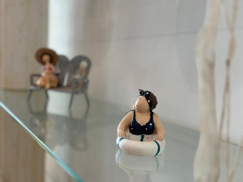 a figurine of a woman sitting on a glass table at DunasDaVagueira in Gafanha da Boa Hora