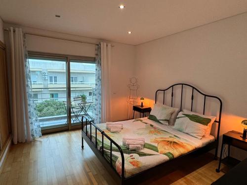 a bedroom with a bed and a large window at DunasDaVagueira in Gafanha da Boa Hora