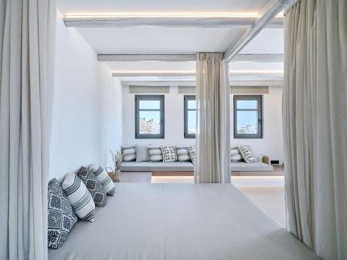 Villa Sol Cielo Naousa Paros في ناوسا: غرفة نوم بيضاء مع سرير كبير مع وسائد