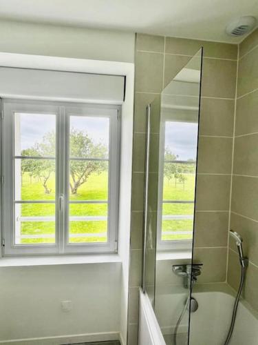 La salle de bains est pourvue d'une fenêtre et d'une douche. dans l'établissement Maison de charme avec vue mer et jardin, à Plouhinec