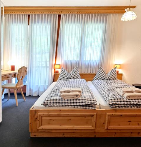 two twin beds in a bedroom with a desk and window at Schöne Ferienwohnung im Zentrum von St. Moritz in St. Moritz