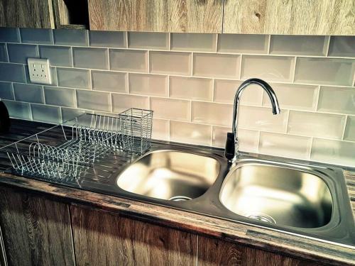 eine Küchenspüle mit einem Abtropfgestell daneben in der Unterkunft Cheerful 3-bedroom vacation home in Kathu