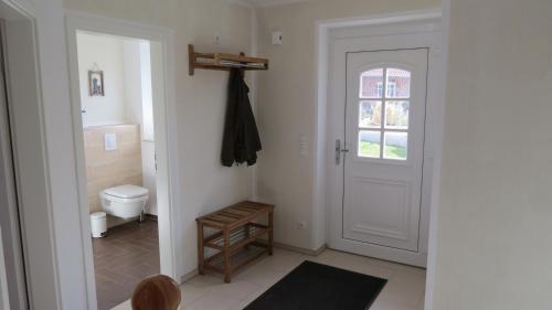 a bathroom with a toilet and a white door at Seeblick in Groß Schwansee