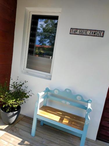 a blue bench sitting in front of a window at Apartament TAM GDZIE ZAWSZE in Wałcz