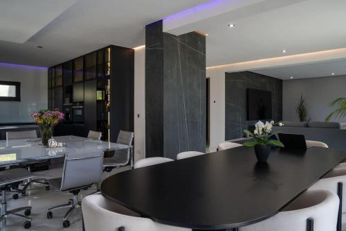 a dining room with a black table and white chairs at Luxury Loft with Pool close to Munich 130qm in Petershausen
