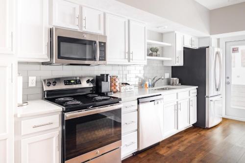 a white kitchen with a stove and a microwave at Luxury Downtown Townhome Unit 5 in Cleveland