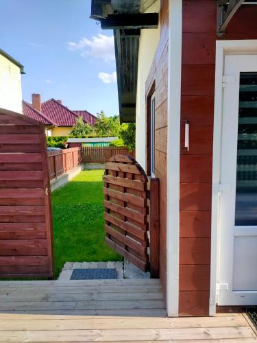 a house entrance with a wooden fence and a yard at Apartament TAM GDZIE ZAWSZE in Wałcz