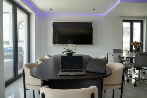 a dining room with a table with two laptops on it at Luxury Loft with Pool close to Munich 130qm in Petershausen