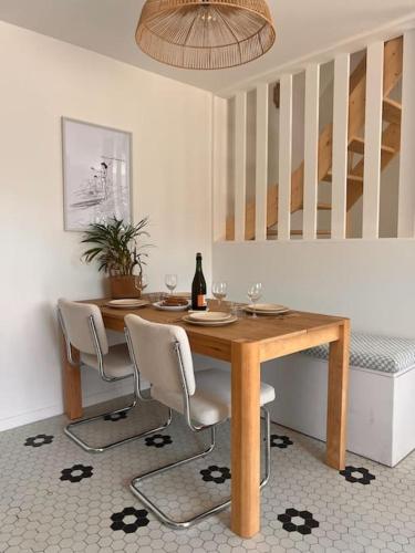 - une table à manger avec des chaises et une bouteille de vin dans l'établissement Maison bretonne rénovée à neuf - Terrasse plein sud - Proche plage, à Perros-Guirec