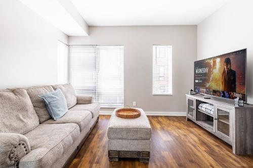 a living room with a couch and a flat screen tv at Luxury Downtown Townhome Unit 13 in Cleveland