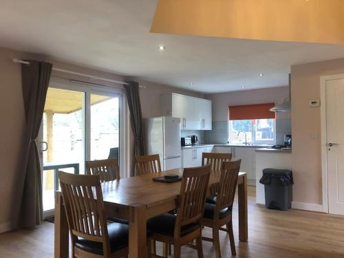 une cuisine et une salle à manger avec une table et des chaises en bois dans l'établissement Barn Owl Lodge with Hot Tub - Adults Only, à Lackford