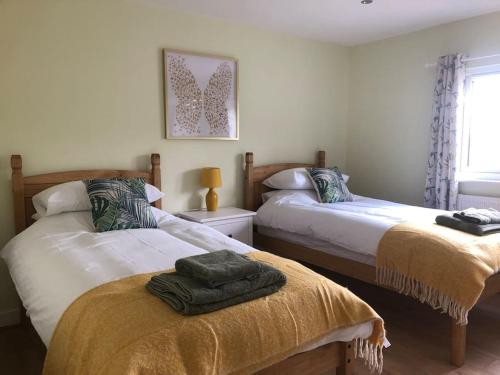une chambre avec deux lits avec des serviettes dessus dans l'établissement Barn Owl Lodge with Hot Tub - Adults Only, à Lackford