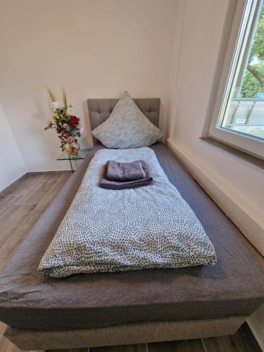 a bed sitting in a room next to a window at Safran Apartments Gunzburg in Günzburg