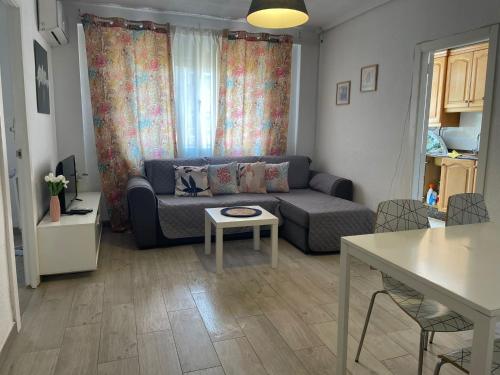 un salon avec un canapé et une table dans l'établissement MALVARROSA BEACH FAMILIAR, à Valence