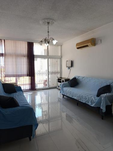 a bedroom with two beds and a large window at Adenaz Apartmanları tatil köyü in Erdemli