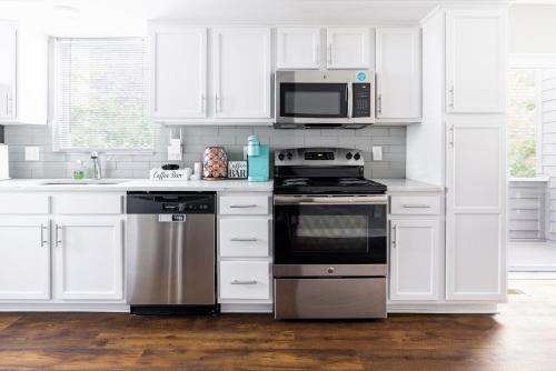 a white kitchen with a stove and a microwave at Luxury Downtown Townhome Unit 14 in Cleveland