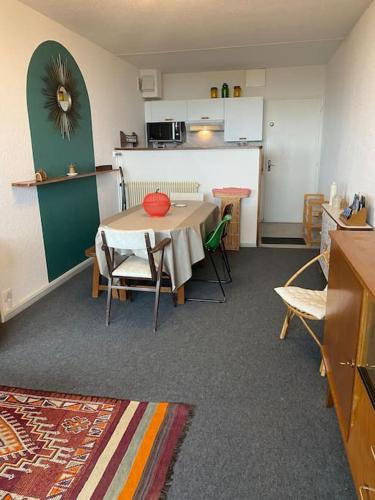Cette chambre comprend une cuisine et une table avec des chaises. dans l'établissement Appartement à la montagne, à Besse-et-Saint-Anastaise