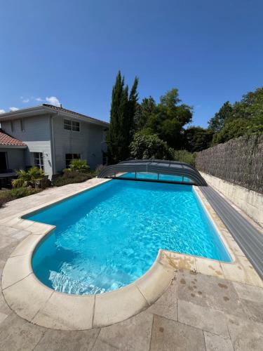 une piscine dans l'arrière-cour d'une maison dans l'établissement Chambres cosy BEN & NAD proches du Puy DuFou, à Saint-Aubin-des-Ormeaux