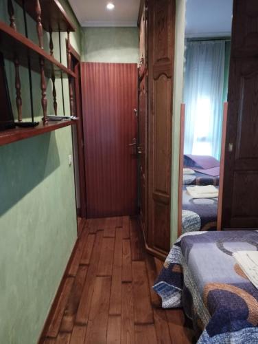 a small room with two beds and a wooden floor at La Casa de Conchi in Comillas