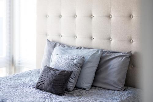 a pile of pillows on a bed with a white headboard at Luxury Downtown Townhome Unit 14 in Cleveland