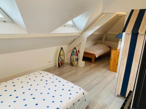 une chambre avec un lit et des planches de surf dans un grenier dans l'établissement Family House near Paris & Normandy, aux Mureaux
