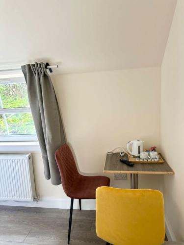 a table and a yellow chair in a room at Edinburgh full house in Edinburgh