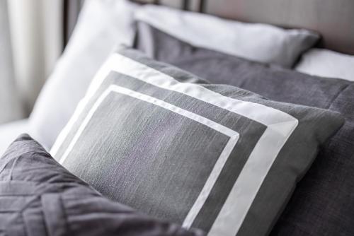 a close up of a bed with a gray blanket at Luxury Downtown Townhome Unit 7 in Cleveland