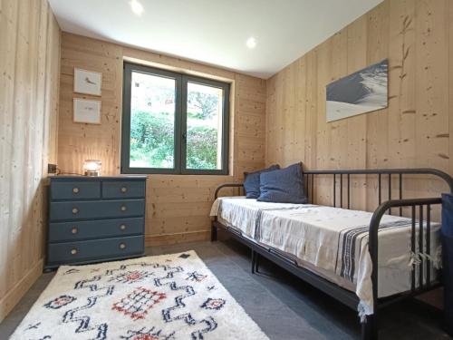 une chambre avec un lit, une commode et une fenêtre dans l'établissement Chalet Le Splendide, à Saint-Gervais-les-Bains