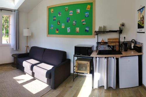 a living room with a couch and a table at Peaceful studio in Coye-la-Forêt in Coye-la-Forêt