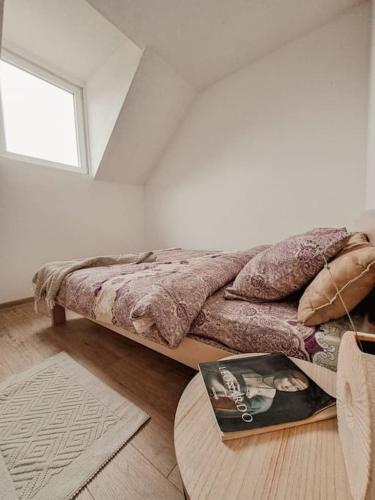 a bed in a room with a window and a rug at Apartman Hači in Kolašin