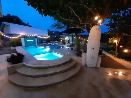 a swimming pool at night with lights at Jaco Surf Beachbungalow in Jacó