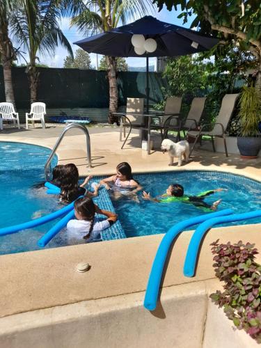 a group of children playing in a swimming pool at Jaco Surf Beachbungalow in Jacó
