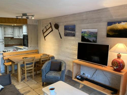 un salon avec une télévision et une salle à manger dans l'établissement Chalet le Chamois-Arolles- Arcs 2000-Alpes-France, à Bourg-Saint-Maurice