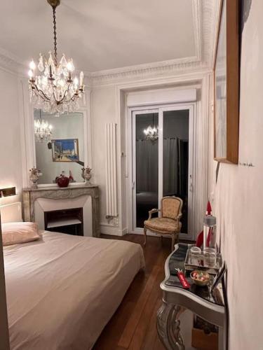 une chambre avec un lit et un lustre dans l'établissement Grande chambre privée sur jardin arboré, à Paris