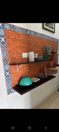 a kitchen with a brick wall with a counter top at Recanto Videira Rota do Vinho in São Roque