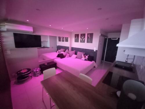 - un salon violet avec un canapé et une table dans l'établissement Studio village naturiste Cap d'Agde Rte 69, au Cap d'Agde