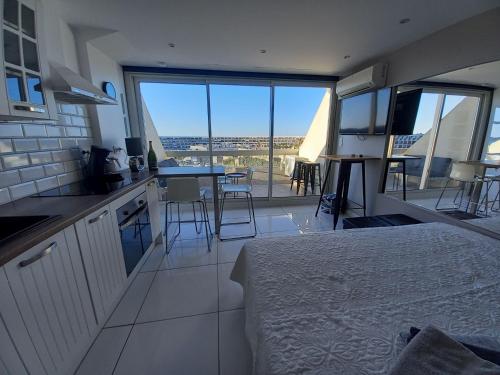Cet appartement comprend une chambre avec un lit et une cuisine avec vue. dans l'établissement Studio village naturiste Cap d'Agde Rte 69, au Cap d'Agde